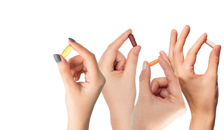 Men's and Women's hands holdin up vitamins.