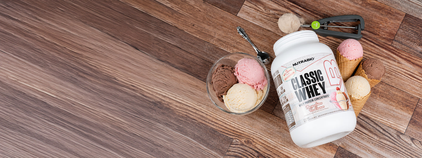 A photo of NutraBio Classic Whey limited edition Neapolitan Ice Cream on a counter top with Ice Cream scoops around it in a medium desktop size.