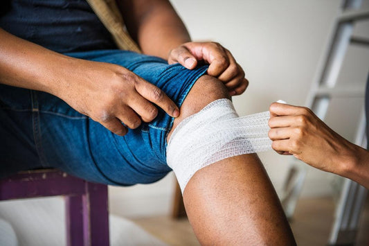 Man's leg with a white gauze wrap around his knee