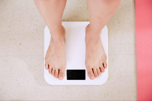 A person stands on a digital bathroom scale, viewed from above.