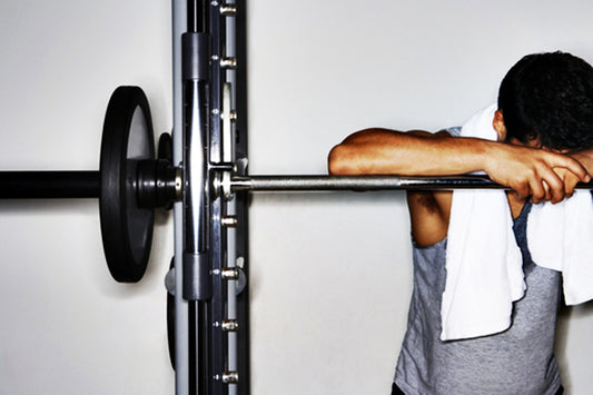 Man leaning on dumbell wrack.