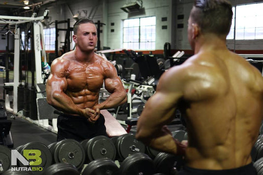 Muscular man posing and flexing his muscles in the mirror