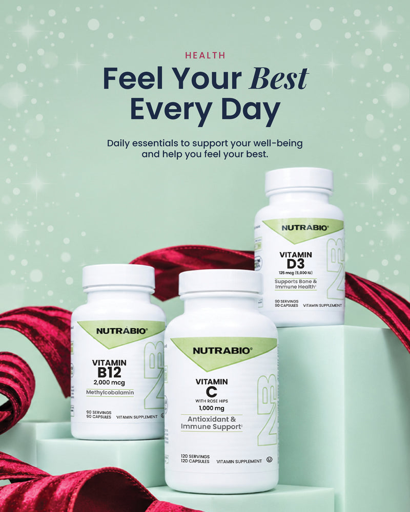 Three bottles of Nutrabio vitamins—Vitamin B12, Vitamin C, and Vitamin D3—arranged on stacked light green platforms with red ribbon accents.